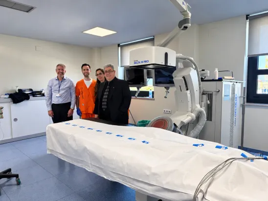 Cuatro profesionales junto a una camilla y un equipo de litotricia extracorpórea en una sala hospitalaria